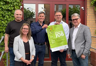 Personengruppe mit Plakat Top to the job