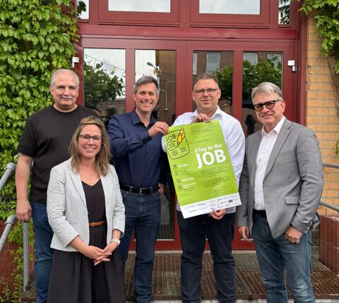 Personengruppe mit Plakat Top to the job