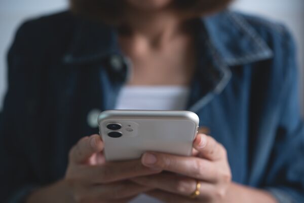 Detailfoto: Frau hält Smartphone in der Hand
